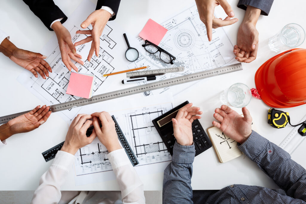 Picture of businessmen's hands on white table with documents and drafts